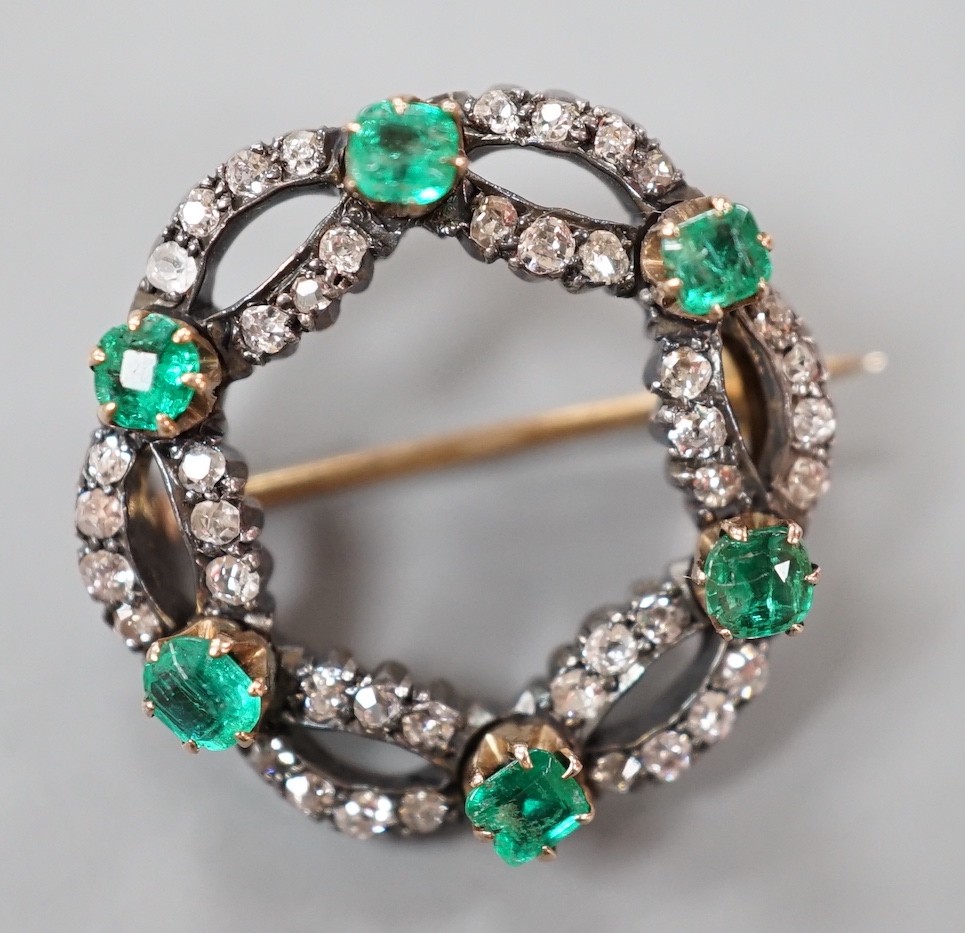 A late Victorian yellow and white metal, emerald and diamond cluster set open work brooch, 21m, gross weight 4.3 grams.